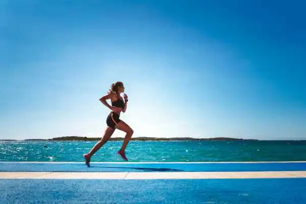Woman running showing strong leg muscle Old Trafford